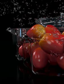 Tomatoes in a plastic tray with 3D effect of splashing water.  